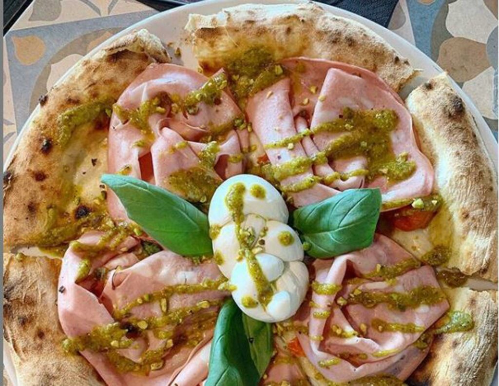 Una pizza squisita con mortadella, bufala e pistacchio