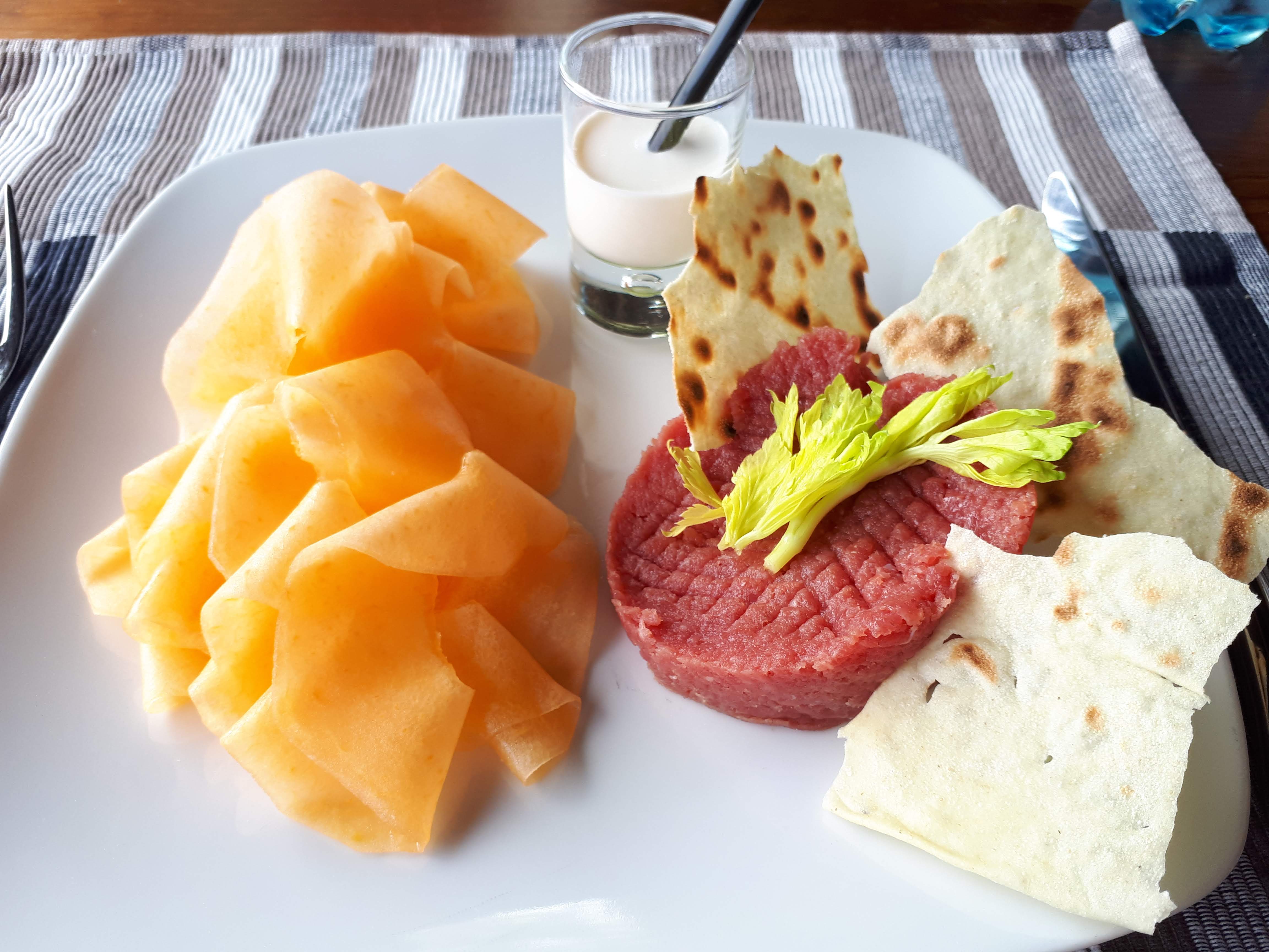 Tartare di fassona alla piemontesecon veli di melone di Lorenzini, chips di pane e crema di latte